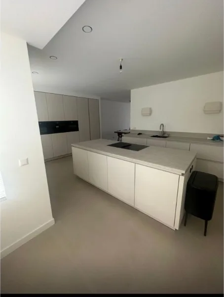 Keuken met wit kookeiland en strak afgewerkt plafond