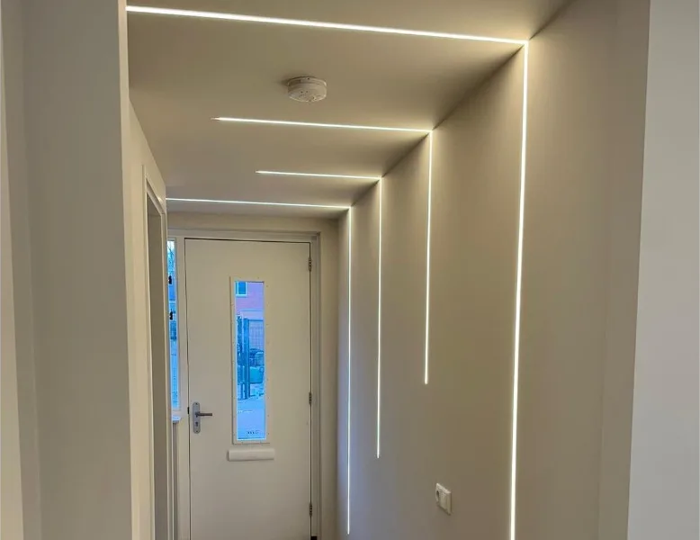 Gang met strak afgewerkte wanden en verticale lichtlijnen