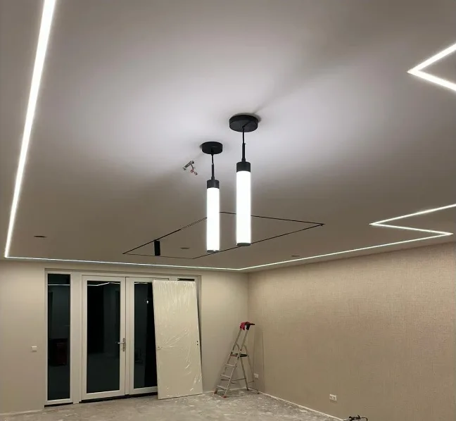 Strak gestuct plafond met ingebouwde lichtlijnen langs de randen en hanglampen