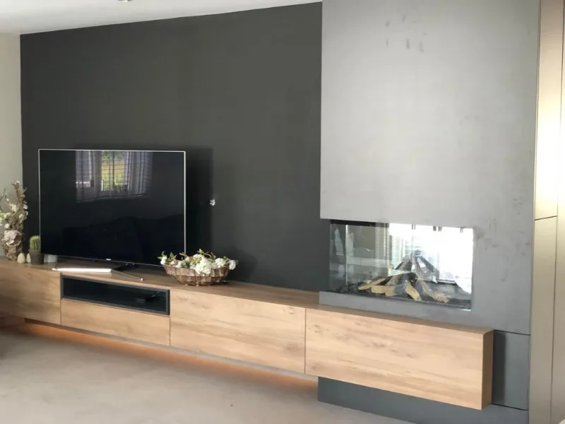 Tv-meubel op maat met ingebouwde haard en betonlook wand