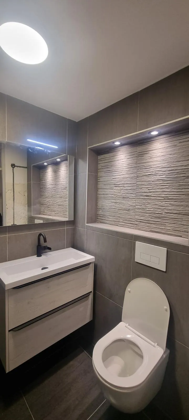Toilet met wastafelmeubel, spiegel, verlichte nis en hangtoilet